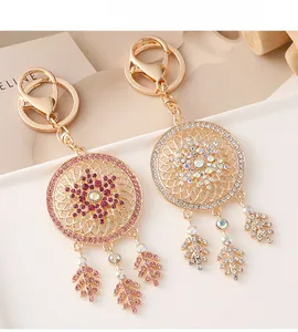 Detail of dreamcatcher keychains with rhinestones and leaf pendants in gold plating
