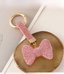 Detail eines rosa Kristall-Schleifenanhängers mit poliertem goldenem Federringverschluss