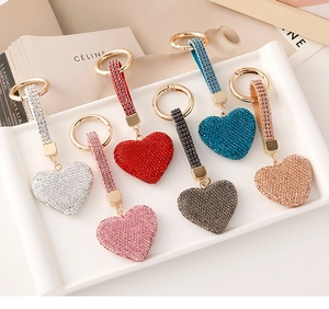 Detail of six colorful heart-shaped rhinestone keychains displayed on a stylish tray