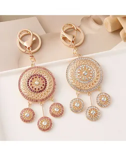 Detail of crystal-encrusted gold dreamcatcher keychain with pink and white rhinestones