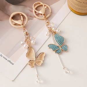 Sparkling butterfly keychain with crystal tassels and pearls in gold and blue tones