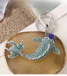 Détail de la broche poisson en strass bleus et porte-clés avec fermoir mousqueton robuste