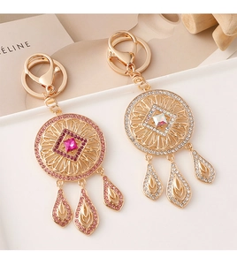 Close-up of golden dreamcatcher keychain with sparkling crystals and drop pendants