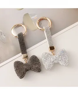 Detail von funkelnden Strass-Schleifen-Schlüsselanhängern in Schwarz und Silber mit Goldring