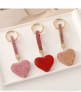 Close-up of pink, red and champagne heart-shaped keychains with sparkling crystals