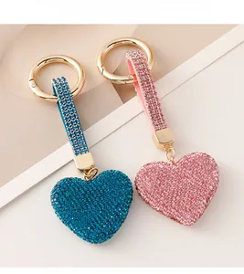 Detail view of heart-shaped rhinestone keychains in deep blue and light pink with gold rings