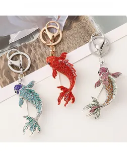 Détails de trois porte-clés carpes koi ornés de cristaux en rouge, bleu-vert et argent