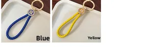 Detail of blue and yellow braided leather keychains with lucky Chinese charms and gold ring