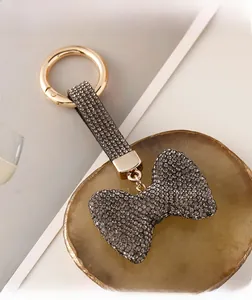 Details vom luxuriösen Schleife-Schlüsselanhänger mit grauen Strasssteinen und Leder