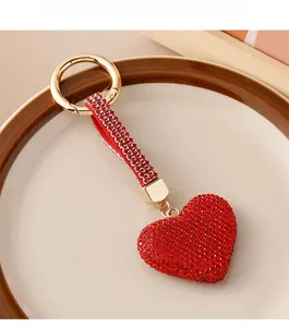 Macro shot of red rhinestone heart keychain with gold metal buckle on a tray