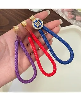 Detail of colorful braided leather keychains with crystal-inlaid 'Cai' pendant