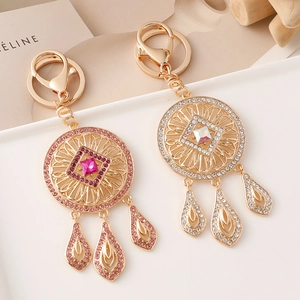 Sparkling dreamcatcher keychain with pink and white rhinestones on golden frame