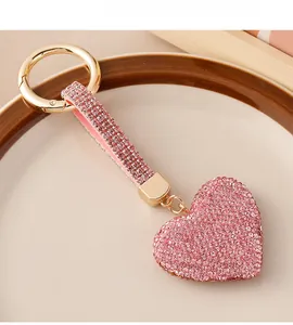 Close-up of pink crystal heart keychain with golden metal ring and sparkling rhinestones