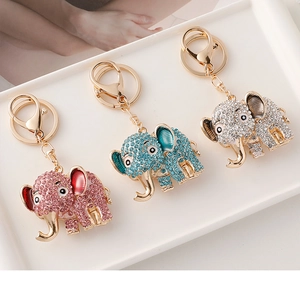 Detailed macro of colorful rhinestone elephant keychains in pink, teal and silver finish
