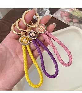 Detail of colorful braided leather wristband keychains in yellow, purple, and pink hues