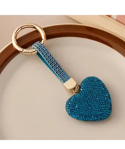 Macro detail of luxury blue heart keychain with crystals and gold hardware on plate