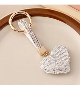 Macro shot of a sparkling heart rhinestone keychain on a white ceramic tray detail