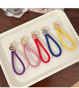 Detail of colorful braided leather keychains with golden rhinestone lucky charms