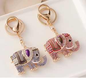 Close-up of purple and pink elephant keychains with colorful rhinestones and enamel details