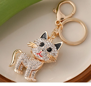 Macro view of gold cat keychain with sparkling crystals on a ceramic background