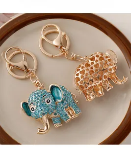 Detailed macro view of gold-plated elephant keychains with blue crystals and heart patterns