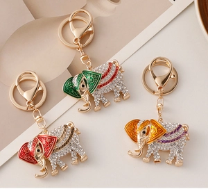 Detail of three jeweled elephant keychains in green, red, and orange with rhinestones