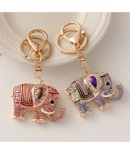 Close-up of golden elephant keychains with pink and purple rhinestones and enamel detail