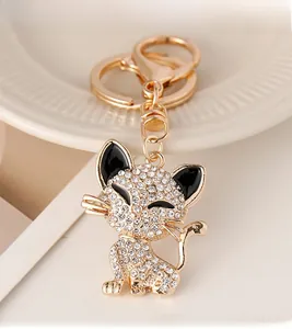Close-up of golden cat keychain with white rhinestones and black enamel eyes on ceramic