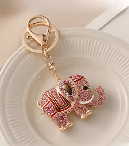 Detailed view of elephant keychain with pink rhinestones and colorful crystals on a white plate