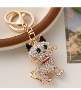 Detailed view of a gold-plated cat keychain featuring sparkling white crystal rhinestones