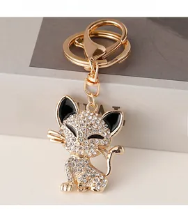 Close-up of golden cat keychain with crystal rhinestones and black enamel detail