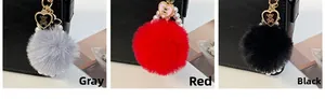 Détail de breloques ours cœur en pompon avec chaînes de perles en gris, rouge et noir