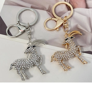 Close-up of goat zodiac keychains with sparkling white rhinestones in gold and silver