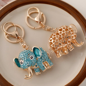 Cartoon elephant keychains with blue crystals and heart patterns on a gold metal base