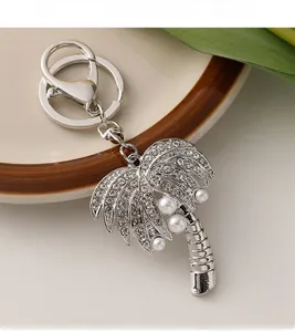 Detail of silver coconut tree keychain with sparkling rhinestones and white faux pearls