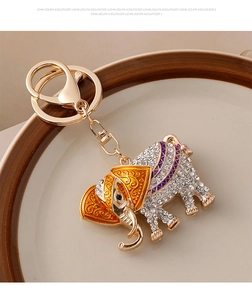 Macro shot of Thai style gold elephant keychain with orange enamel and crystal pavé details