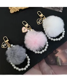 Détail des porte-clés en peluche avec anneaux de perles et pendentifs cœur d'ours