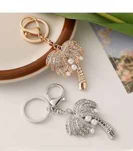 Close-up of gold and silver coconut tree keychains with pearls and rhinestones
