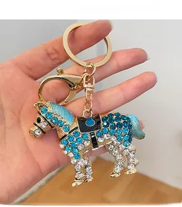Gros plan détaillé d'un porte-clés cheval doré avec strass bleus et fermoir mousqueton