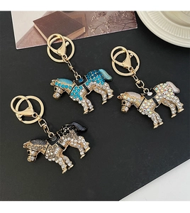 Vue détaillée de porte-clés chevaux en bleu paon, aurore et strass noirs avec métal doré