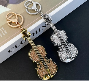 Detail of violin keychains with gold amber rhinestones and silver clear crystals