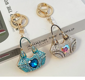 Detailed close-up of crystal studded handbag keychains in peacock blue and silver white