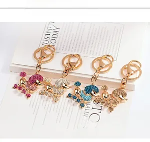 Vue détaillée de quatre porte-clés caniche en strass colorés rose, argent, bleu et doré