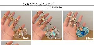 Three crystal-encrusted handbag keychains in gold, silver, and blue with heart accents