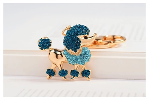 Détail d'un porte-clés caniche plaqué or orné de strass bleus dégradés et scintillants