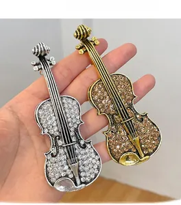 Detail shot of violin brooches in gold and silver finish with sparkling rhinestones