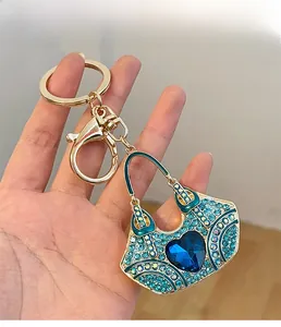 Detail of blue crystal heart handbag keychain with sparkling rhinestones and gold clasp