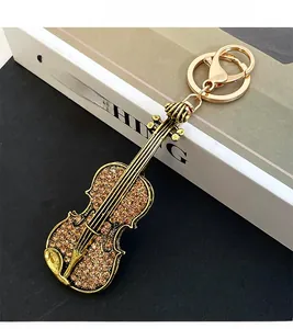 Detail of vintage violin keychain with sparkling brown crystals and golden metal lobster clasp