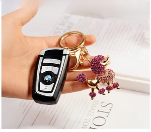 Vue détaillée d'un porte-clés caniche en strass rose attaché à une clé de voiture