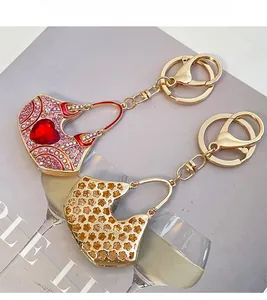 Detail of crystal handbag keychains with pink rhinestones and gold floral filigree
